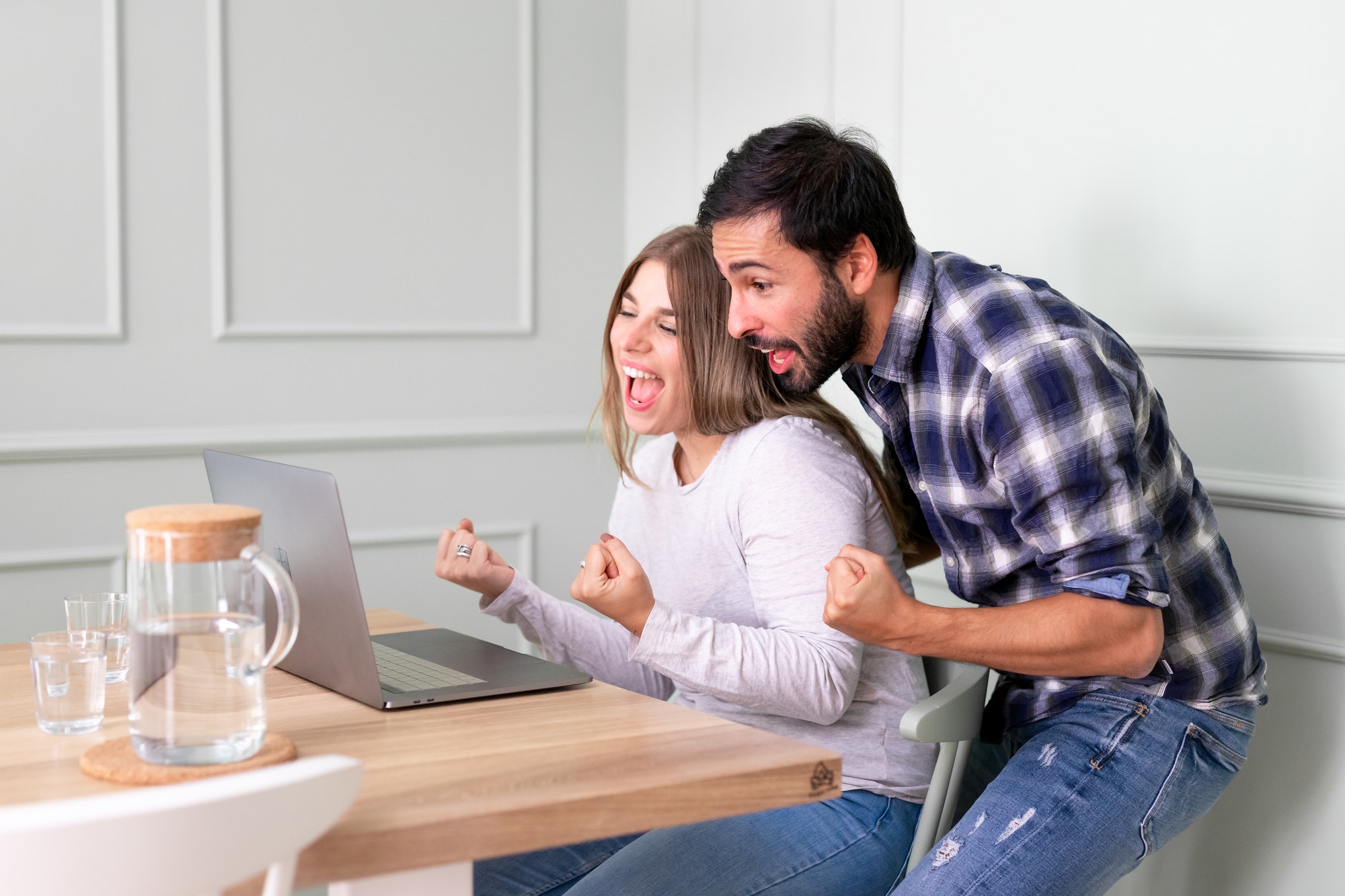 Caucasian couple looking at pc screen feels excited celebrating mortgage approval