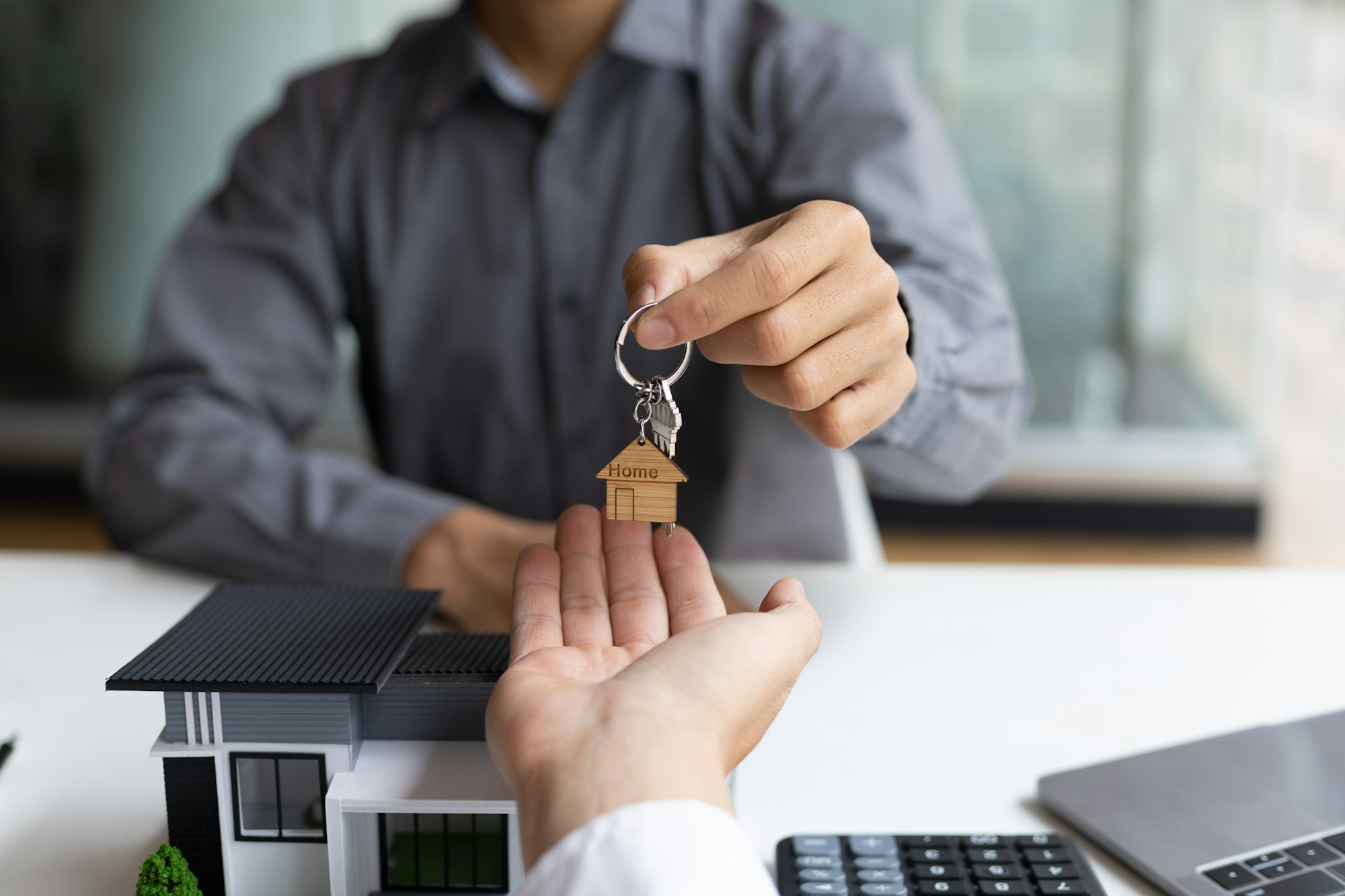 Real estate agent hands over the house keys to a homebuyer in Ontario