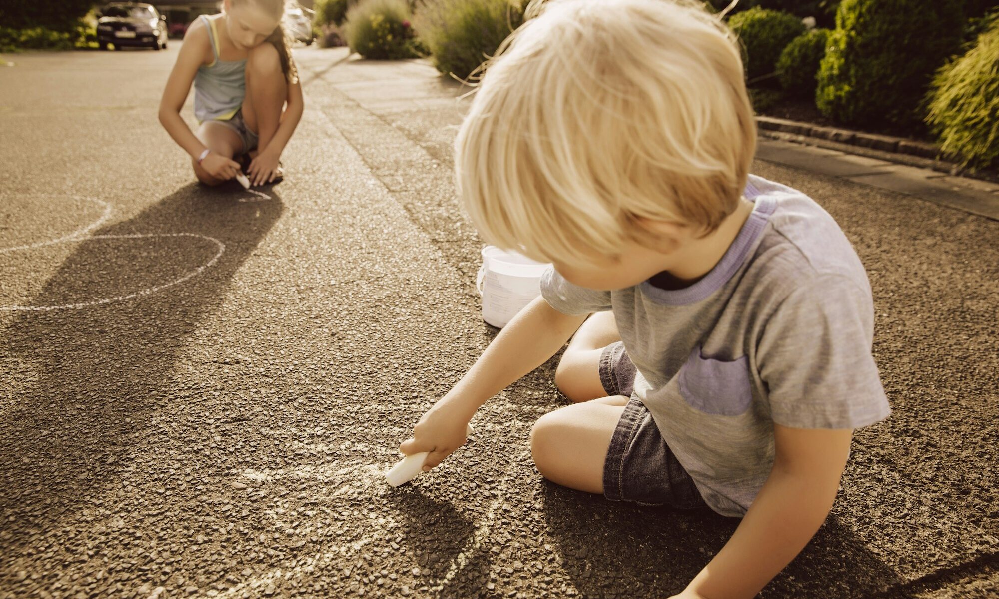 Children using sidewalk chalk in kid-friendly neighborhood