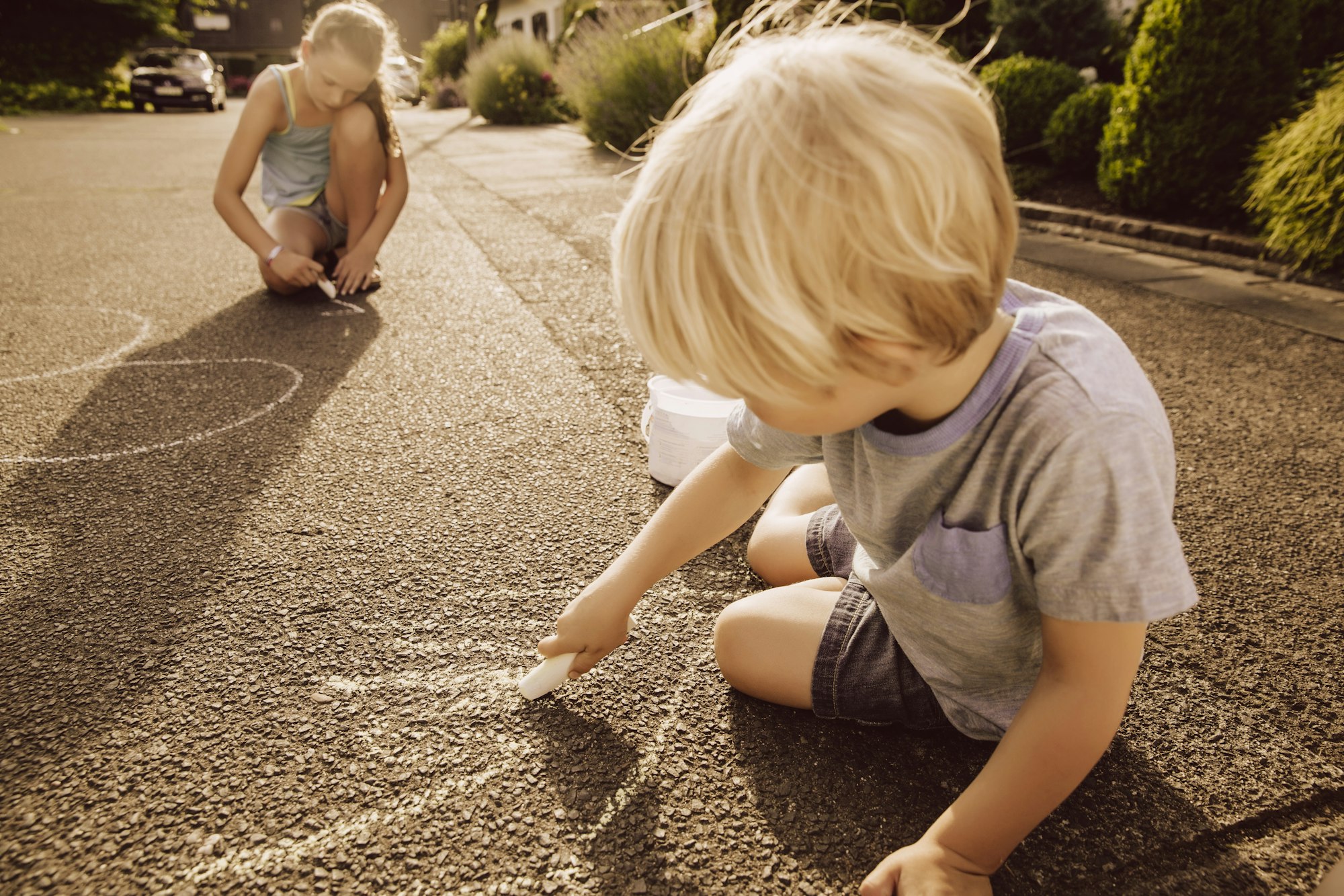 Children using sidewalk chalk in kid-friendly neighborhood