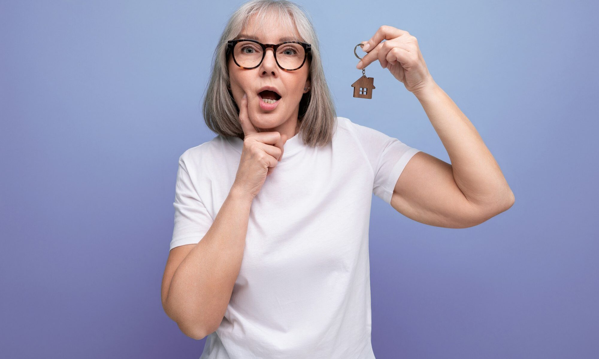 turnkey property. mature woman pensioner holding apartment keychain